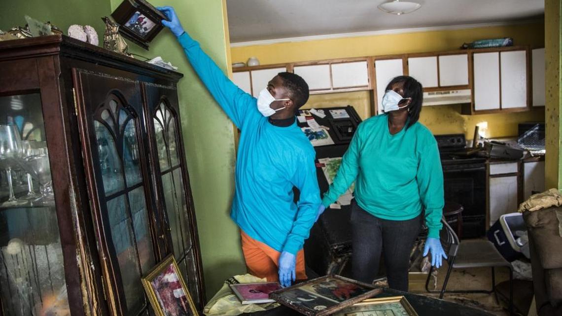 Justin Williams and his mother Theresa Williams find a family photo while assessing damage and salvaging belongings Oct. 25, 2016 at their home in Princeville, NC, after Hurricane Matthew.