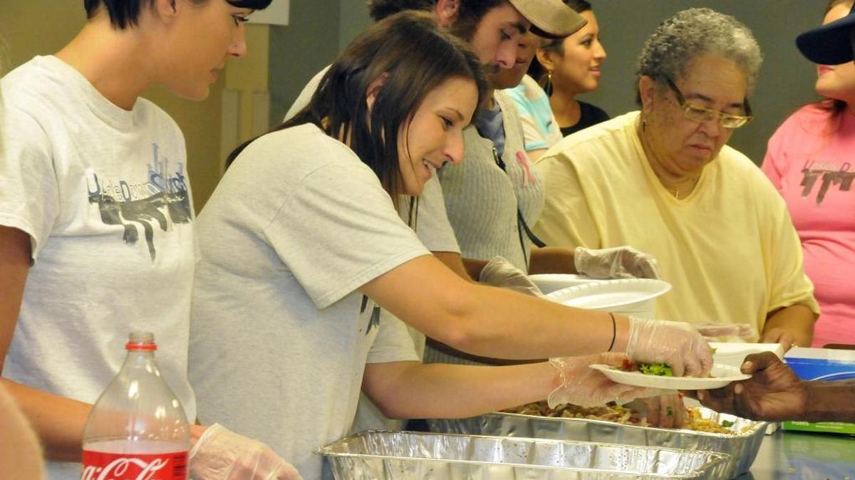 Lindsey Mohnacky (center serving plate) and other volunteers of UpsideDown Church in action as church volunteers serve food to the homeless at the Hal Marshall Building on N. College St. Story will focus on a county program that lets churches and civic groups use county property to feed homeless people indoors. The program is credited with cutting down on loitering in uptown. Diedra Laird - dlaird@charlotteobserver.com