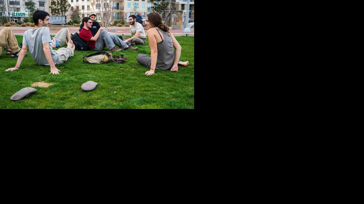 
 Students from the State University of New York at Syracuse – including Alex Arams, left, Matt Tramantano, in red shirt, and Elyna Grapstein, right – take time out on the green at Romare Bearden Park in uptown Charlotte to enjoy Monday’s warm weather. The students and a professor had missed a flight at Charlotte Douglas International Airport and were scheduled to fly back to New York on Monday night. Part of the school’s college of environmental science and forestry, they had been on a trip to Costa Rica. 
