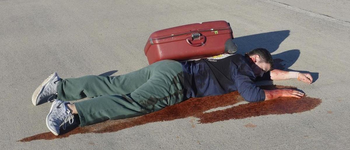 Volunteer Rick Brooks of Charlotte waits on the tarmac for medical attention playing the role of passengers from a Airbus A319 plane that collided with a small plane. Charlotte Douglas held a Triennial Part 139 Disaster Exercise on Sunday, October 5, 2014 involving a simulated airplane incident.