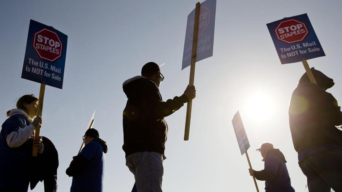 Postal workers and their supporters demonstrate outside a U.S. Postal Service facility in Philadelphia, Pa., in April 2014.