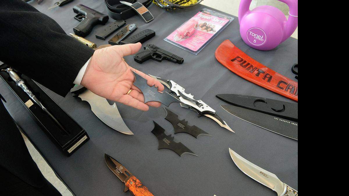 
A security official holds one of several Batman batarangs recently seized from an airport traveler on display with other seized items at Wednesday's TSA /Charlotte Douglas International Airport/CMPD press conference at Charlotte-Douglas International Airport on Wednesday April 28, 2015. Officials displayed dozens of knives, guns, and other weapons not permitted in carry-on bags that have been recently seized from airport travelers. 
