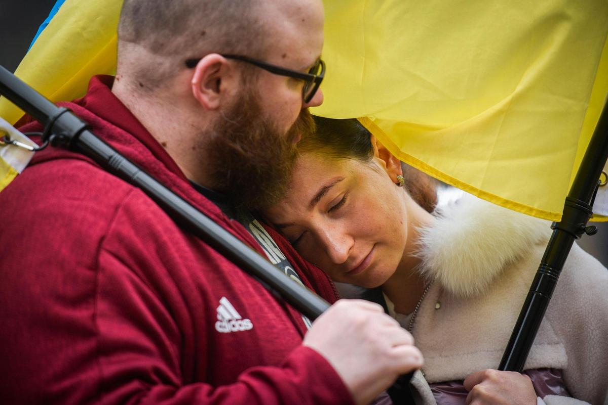 Travis Keery embraces his wife Tetiana Kytaiova, both of Kannapolis, N.C. during a gathering to show support for Ukraine following Russia’s invasion and bombing at Romare Bearden Park in Charlotte, N.C. Thursday, Feb. 24, 2022. Kytaiova was born in Ukraine and moved to the United States eight months ago.