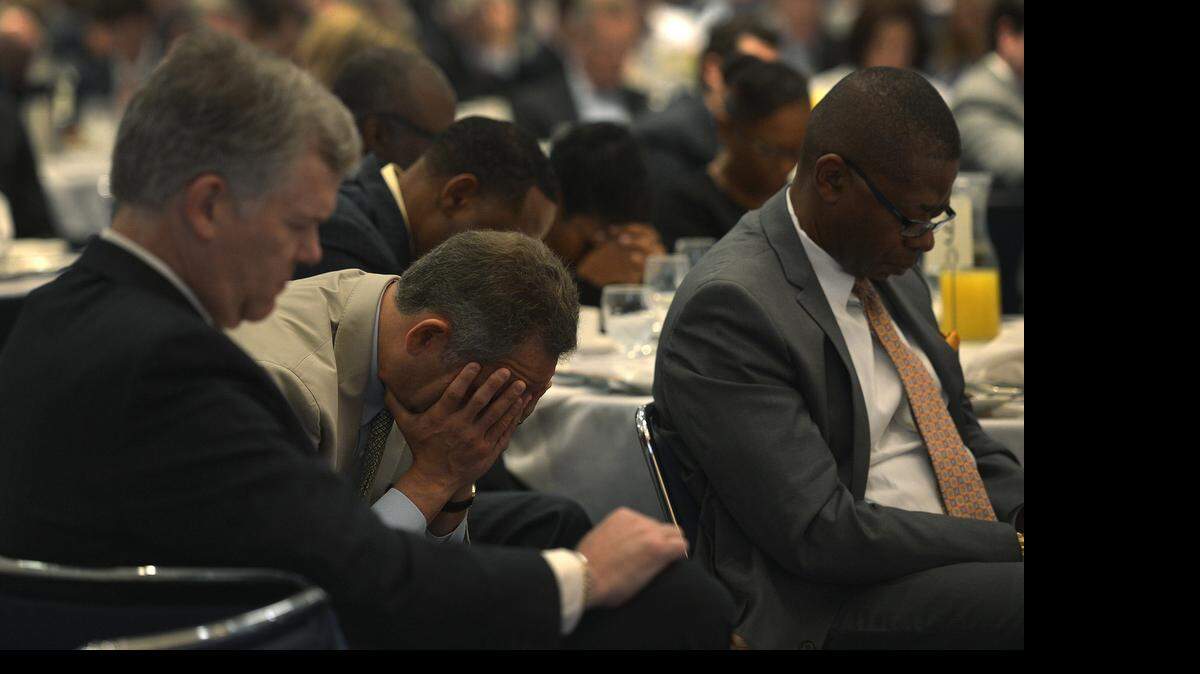 
Folks bow in prayer at 28th Annual YMCA of Greater Charlotte Community Prayer Breakfast, Thursday April 30, 2015. Guest panelists Nancy Writebol and Harry Jones discussed how prayer sustained them during their recent brush with mortality.
