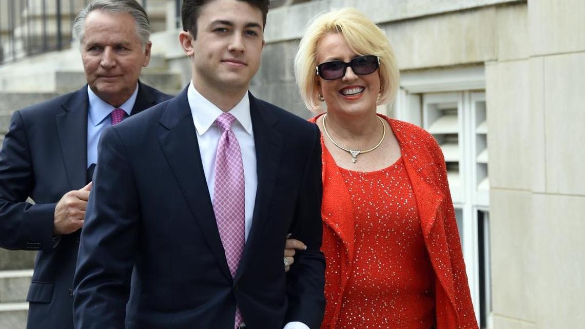 In this May 19, 2017, file photo, Brooke Covington, right, a member of the Word of Faith Fellowship church in Spindle, N.C., leaves a hearing at Rutherford County Courthouse, background, in Rutherfordton, N.C., accompanied by an attorney, Joshua Valentine, left, and her husband, Kent Covington. A man has been charged with harassing the jury that is deliberating in the trial of Brooke Covington, a North Carolina minister accused of beating a congregant to expel his â€œhomosexual demons.â€ The man apparently made a comment Tuesday, June 6, 2017, to the jurors in a hallway that they needed to reach a verdict. Deliberations began Monday, June 5. (AP Photo/Kathy Kmonicek, File)