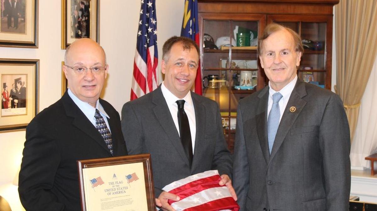In honor of their father, Garland Denny, James and Chuck Denny, left and center, accept the U.S. flag from U.S. Rep. Robert Pittenger in Washington, D.C., on Oct. 21, 2015.
