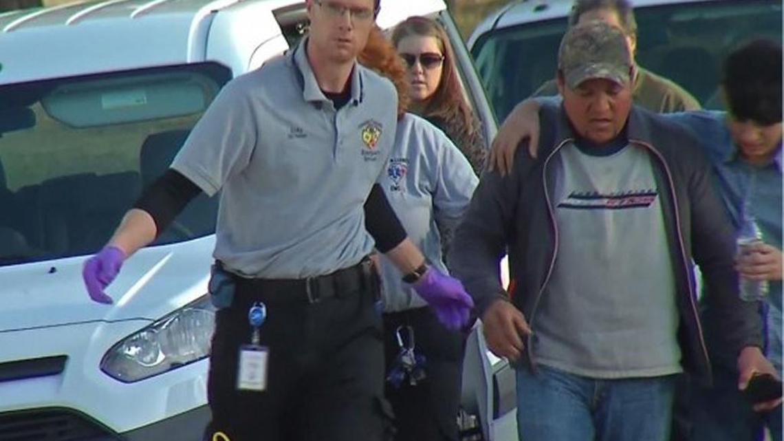 Officials escort a family member from the scene of the homicide at Funes-Machado home.