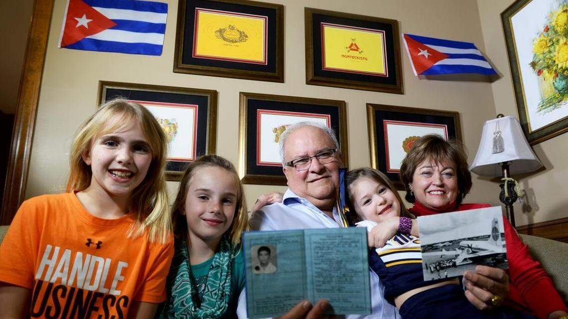 Jorge Guzman, center, holding some of the memorabilia from his exodus to America from Cuba as a child, including his passport as a child, left, and a photo of the plane he flew on, right. He is surrounded in his home by left to right daughters Reagan,11, Taylor, 8, and Emme Britt, 5, and his wife Nancy. Jorge Guzman was born in Cuba and lived there until he was 8, when in January 1961 -- two years after the start of Castro's revolution -- his parents put him on a Pan Am plane bound for Miami as part of a slow, quiet exodus of 14,000 Cuban children to America and freedom. Recently, after 55 years, he returned to Cuba for the first time.
