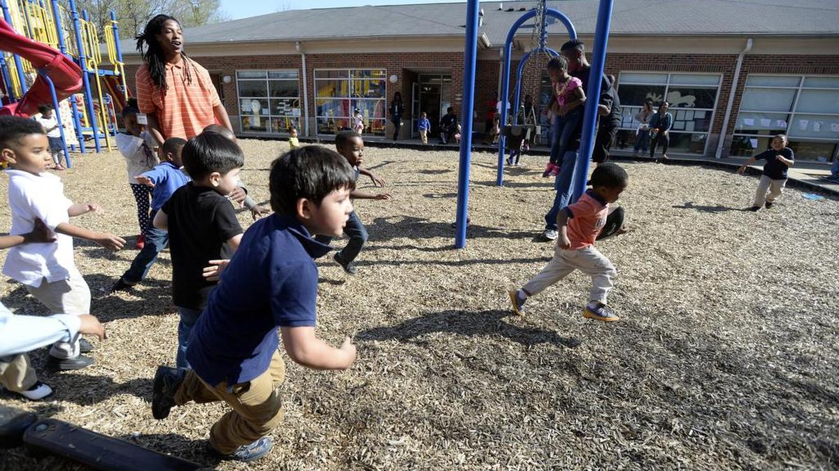 A group of kids run while playing some football on the playground at The Learning Collaborative on Wednesday, March 16, 2016. The center has successfully bought a new home in Grier Heights and will move out of the YMCA site by the fall.
