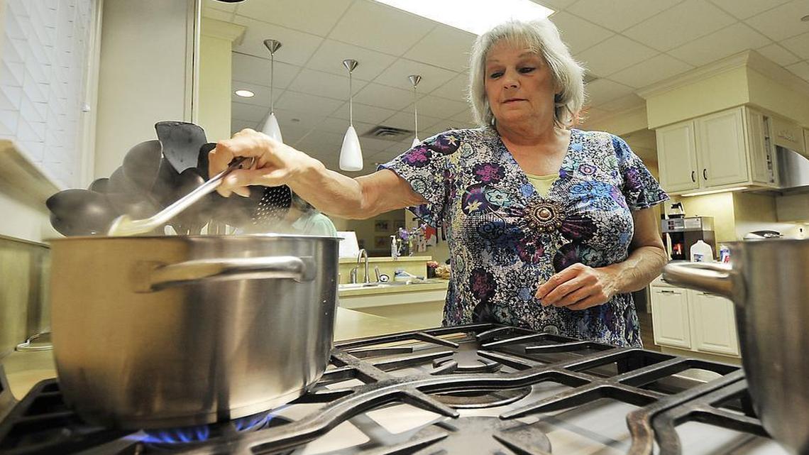 
Debra Harvey ate, slept and changed clothes in her Chevy Tahoe for 19 days before Charlotte’s Hospitality House learned of her plight and offered the disabled retiree temporary food and shelter at no cost. In this Observer file photo, Harvey is shown helping out at the charity in October 2012 during her stay. 


