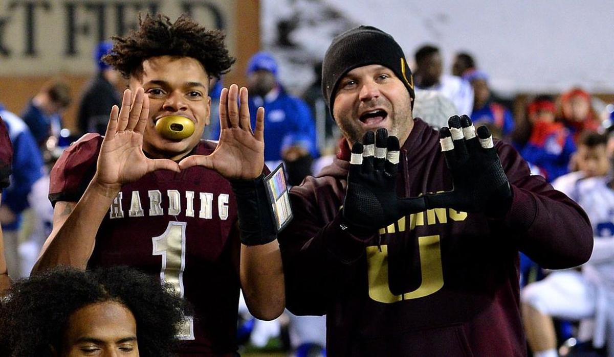 Harding quarterback Braheam Murphy, left and coach Sam Greiner celebrate the team’s victory over Scotland County in the 4A state championship on Dec. 9. Harding defeated Scotland County 30-22.