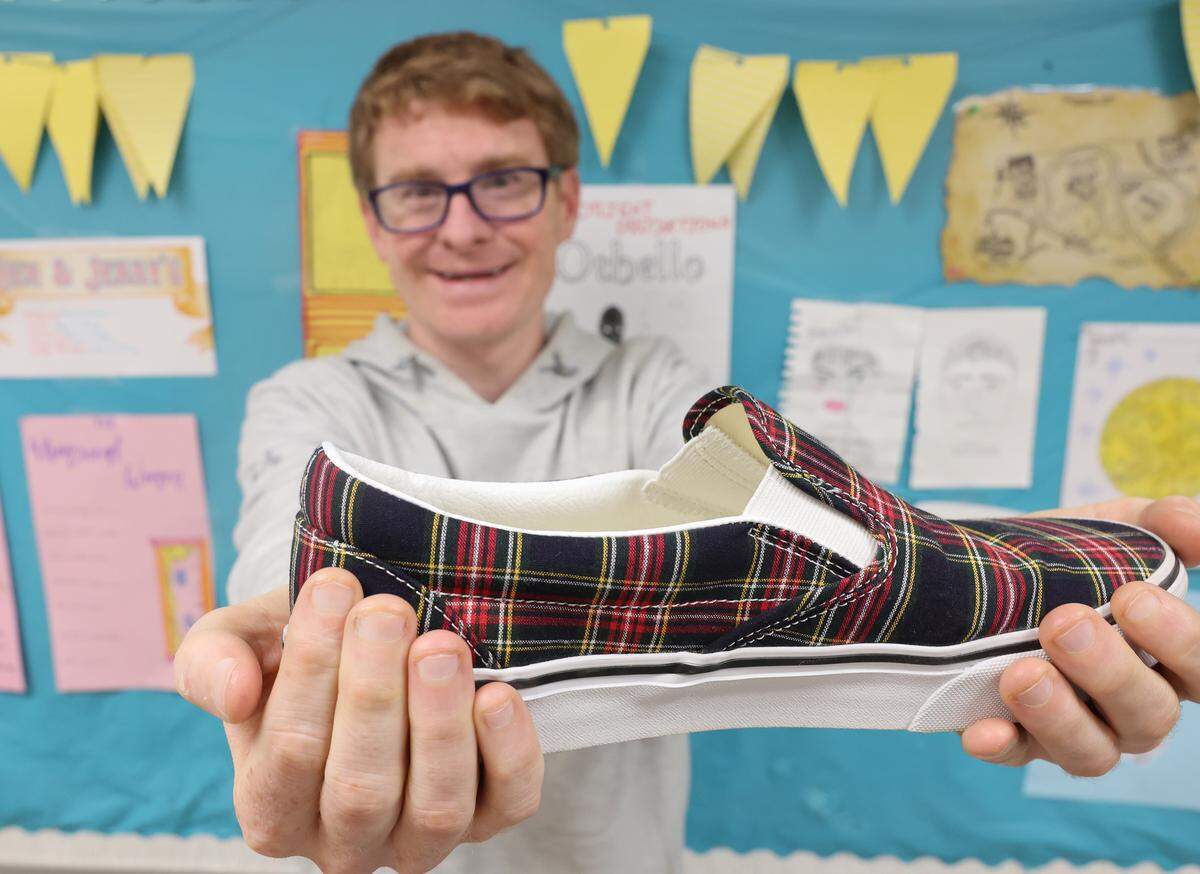 Jeff Swicegood, a teacher at Providence High School, holds a pair of Vans shoes his students gave him.