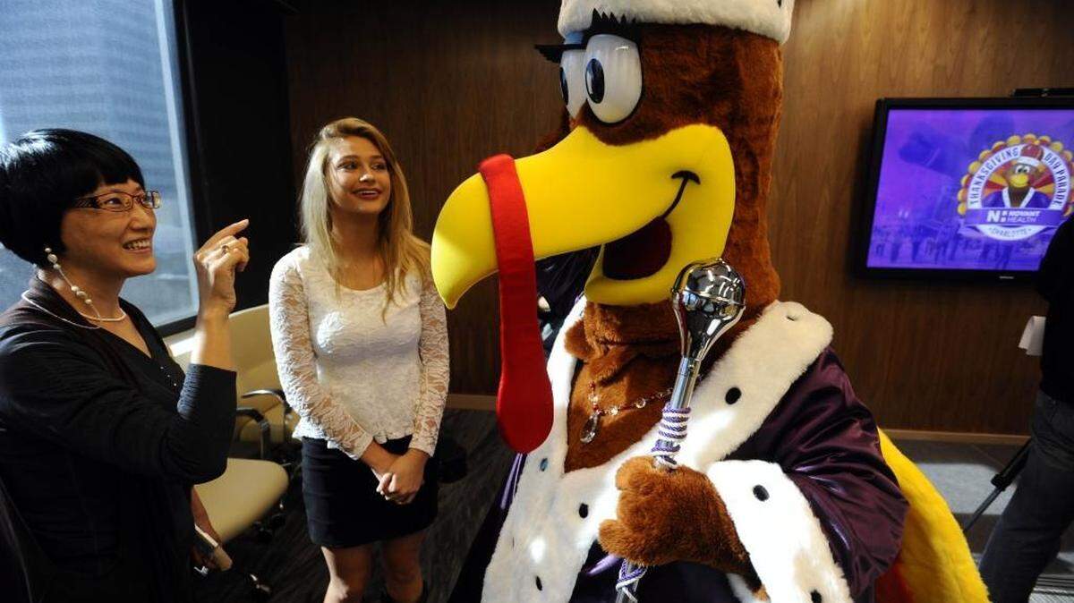 (left-right) Chunhong Wang, a creative arts therapist, and singer Tiffany Ashton, has fun meeting Queen Charlotte, the mascot of the Novant Heath Thanksgiving Day Parade, after a press conference about the upcoming event at Charlotte Center City Partners on Thursday, October 22, 2015. The 2015 Novant Health Thanksgiving Day Parade will feature NASCAR legend Richard Petty as grand marshal.