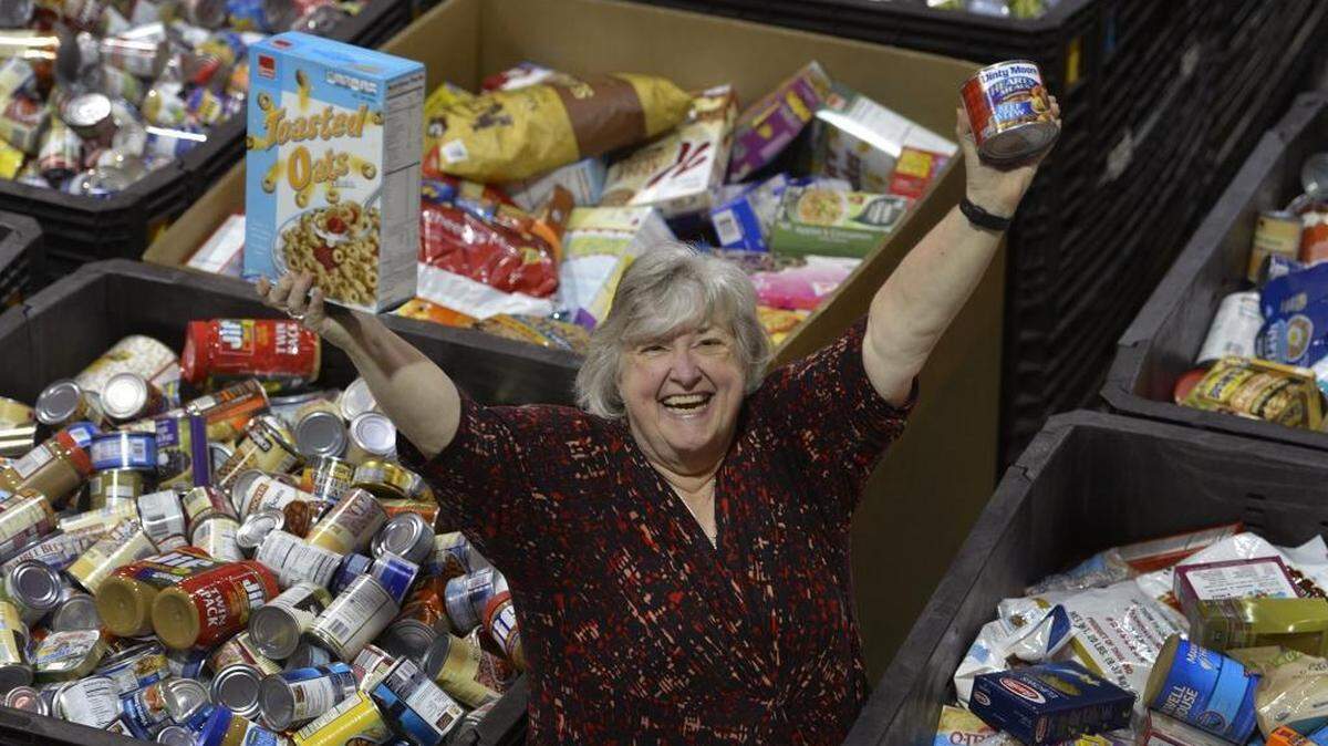 Beverly Howard, Executive Director of Loaves & Fishes is surrounded by mountains of food the agency collected during Scouting for Food event this past week.