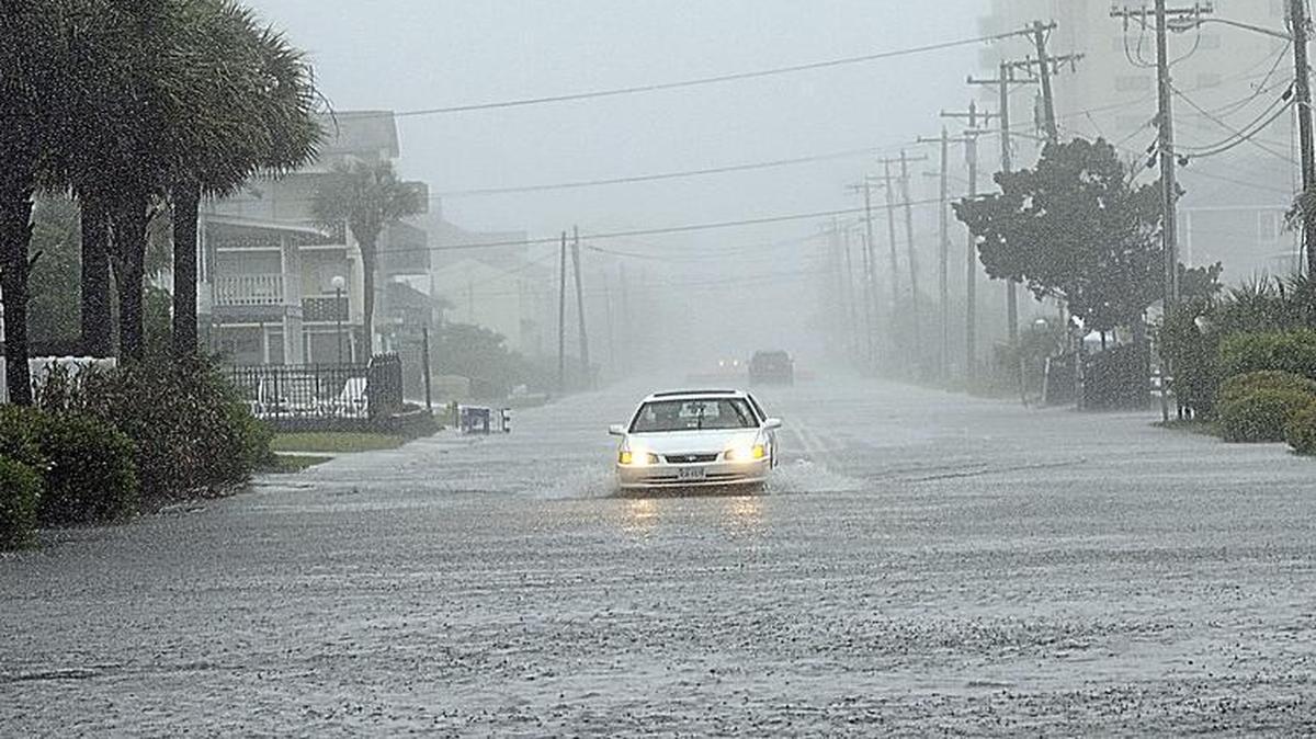 
A car drives south on a flooded Ocean Boulevard after it drove past barricades warning of the high water Sunday, May 10, 2015, in North Myrtle Beach, S.C. Tropical Storm Ana lost the last of its strength and was downgraded to a depression as it created wet and windy conditions along the North and South Carolina coasts. 
