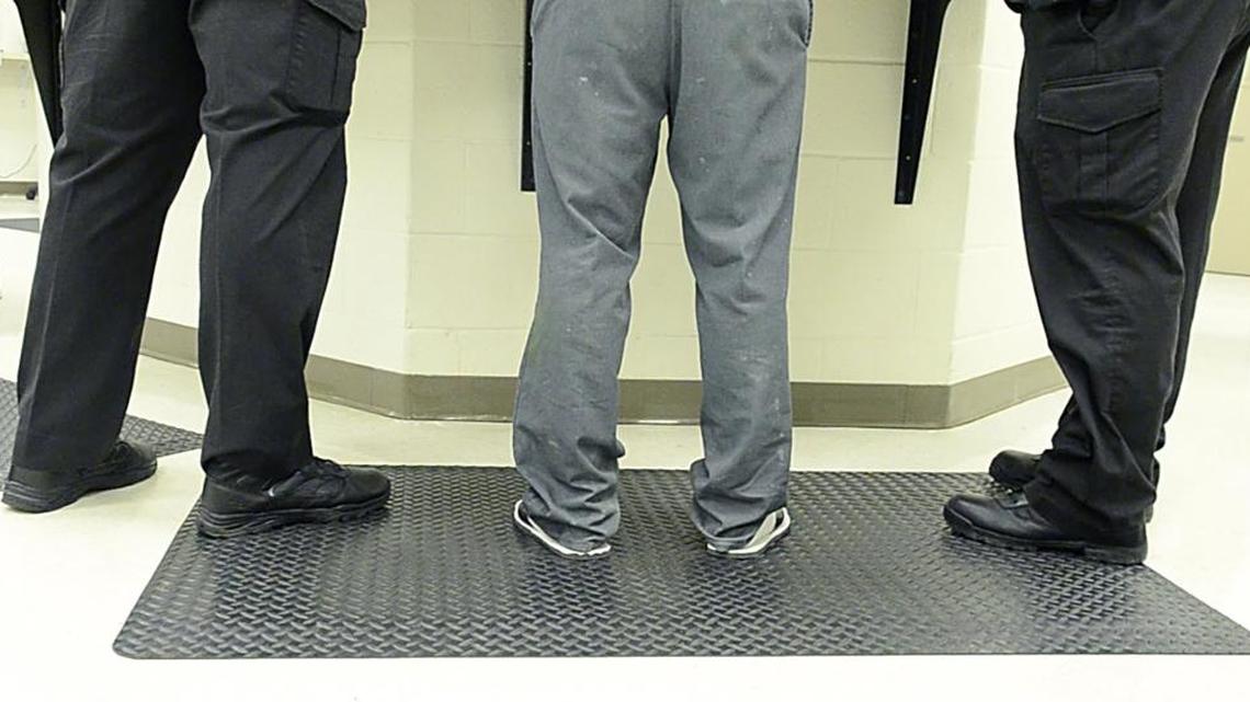 A person goes through initial processing at the booking desk of Mecklenburg County Jail Central.