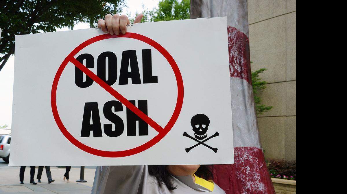 
A protester wields a sign before Duke Energy's annual shareholder meeting in Charlotte last Thursday.
