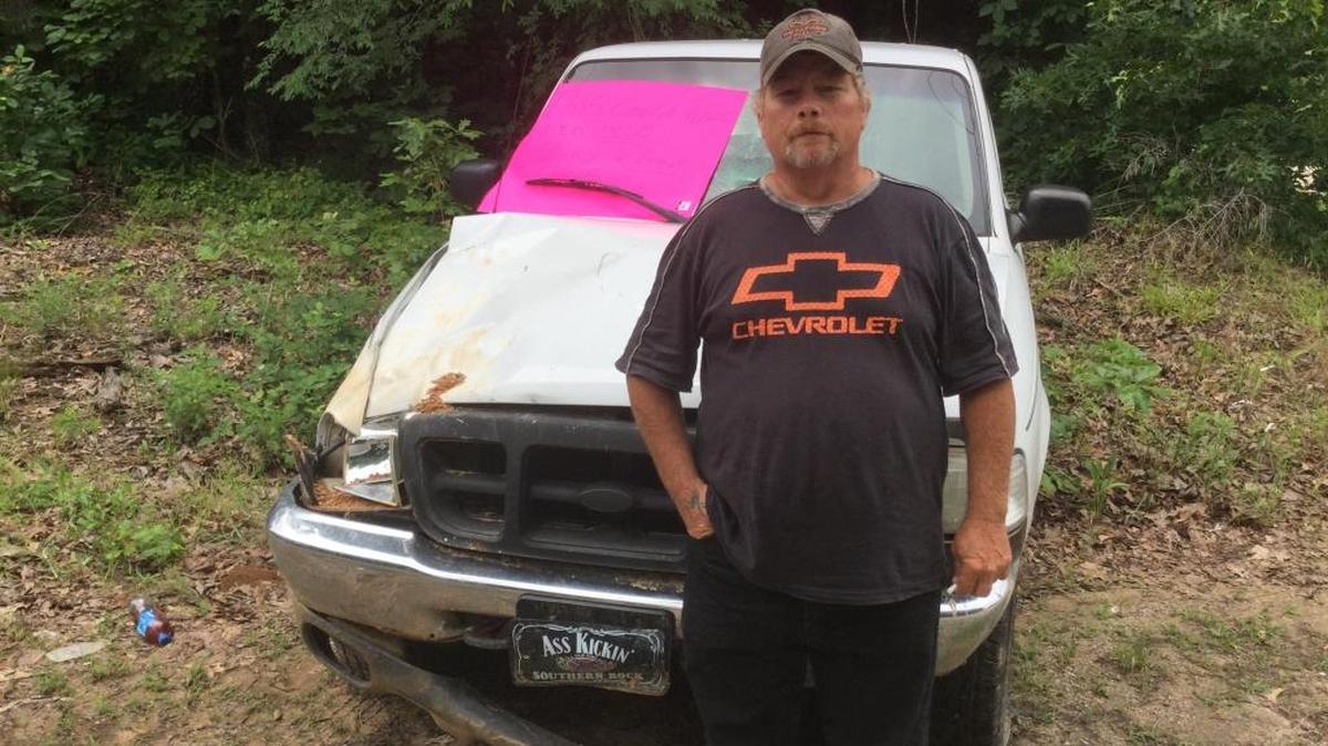Charles Sims of Chester County with the truck he was driving when he drove into a sinkhole on a rural road Sunday night.