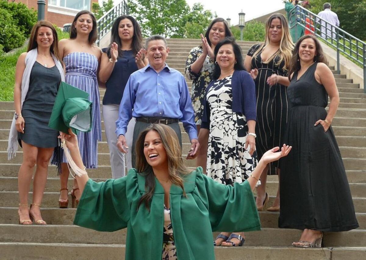 Crystal Cruz surrounded by her family before she graduated at UNC Charlotte Friday afternoon. Crystal is the last of seven sisters of immigrant parents from El Salvador to graduate college, five of them from UNCC. (L to R) behind Crystal in center are; Jose (dad), Maria Carmen, (mom). (Sisters L to R) Karen, Katie, Lucy, Corina, Emma and Elizabeth.