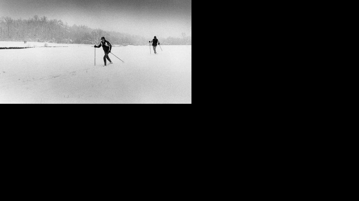 
Spring may have arrived as far as the calendar is concerned, but it was tough to tell when the snow fell Thursday, March 11, 1983 in Charlotte. UNCC students Bill McMillan and Tom Lambert took advantage of the surprise weather and spent the afternoon cross country skiing on a campus athletic field.
