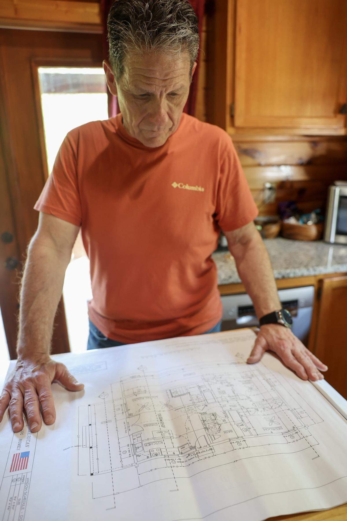 Ed Danyo looks over blueprints that would have been his log home in Millers Creek, N.C., on April 22, 2026.