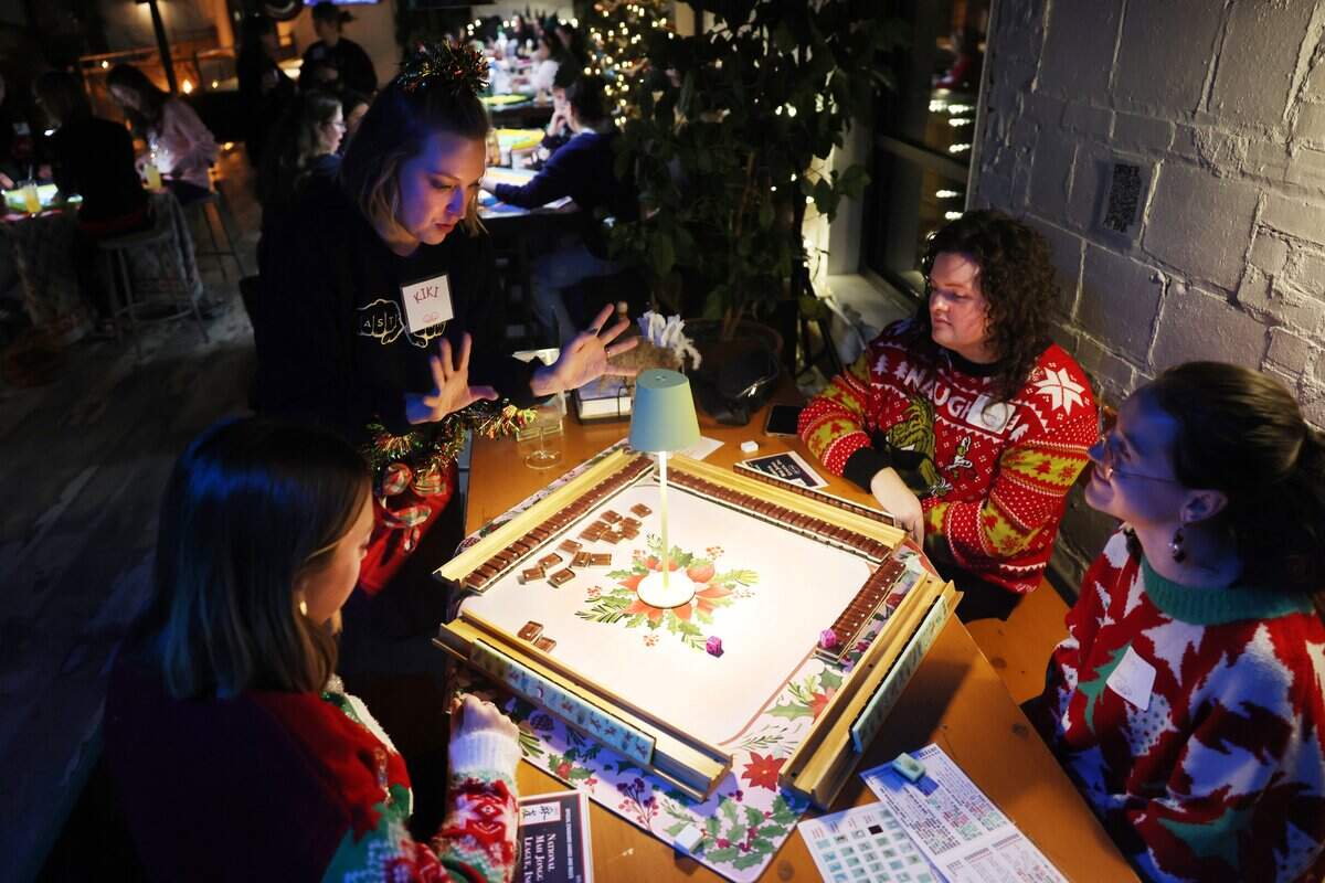 Kiki Poland of Eastside Mahjong, second from left, teaches a group of women how to play the game Tuesday at Salud Cerveceria in NoDa. From left are Triana Gorman, Cassidy Lecher and Karley Wilson