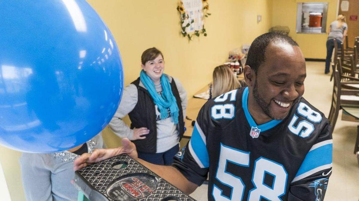 Harry Mack gets off a ladder while decorating the Salvation Army Center of Hope on Thursday for Sunday’s Super Bowl 50 party.