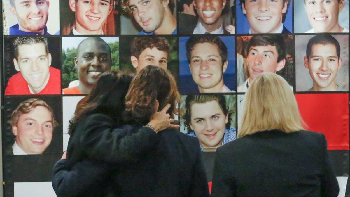 Debbie Smith, left, comforts Julie DeVercelly while standing before the portraits of their son's and the son's of others who have died in incidents of hazing with Leslie Lanahan. The women are attending a weekend conference for parents who have lost children due to hazing.