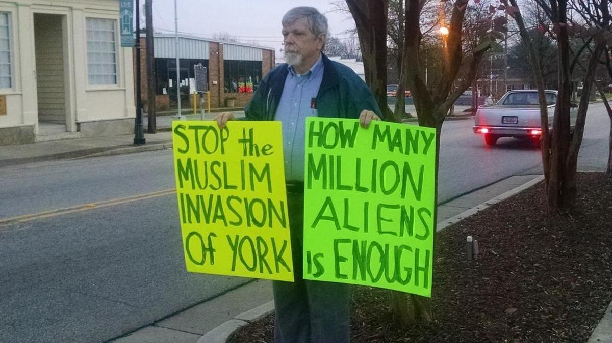 Nelson Waller of Anderson holds signs outside York County’s administraton building on Monday, just before the county council voted on a resolution opposing the resettlement of Syrian refugees.