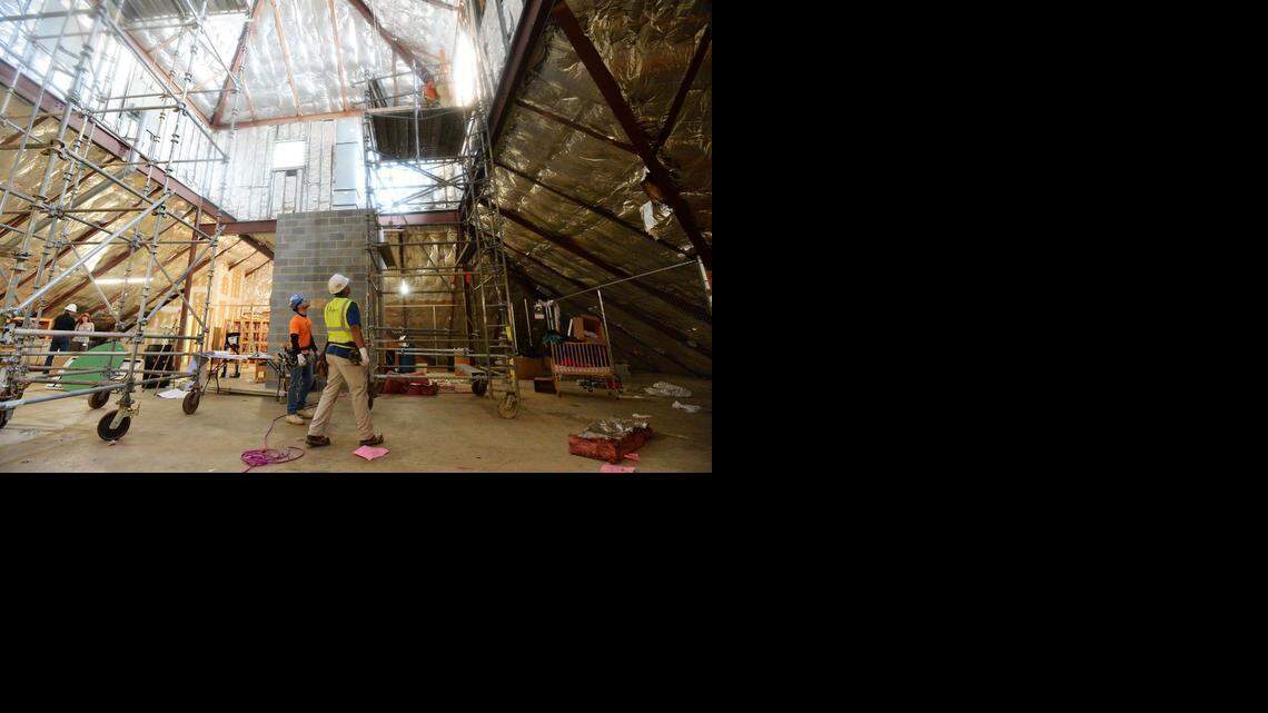 
 Workers with Precision Walls of Charlotte ( L-R, below), Michael Martinez, foreman supervisor Guillermo Fuentes, Freddie Martinez (above), install lumber on March 11,2015 to protect window openings that have been installed part of the third floor expansion at the Salvation Army Center of Hope shelter construction that is underway for a new dorm that will have space for 64 shelter beds. 
