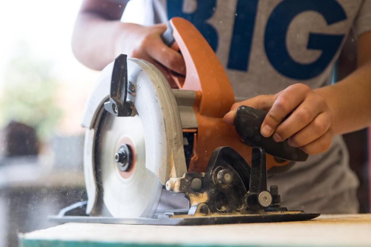 Skye Pruess uses a power saw to cut wood for a little free library on Wednesday. Local high school students work to build little free libraries for the community at one of CPCC's STEM Summer Experience camps on Wednesday.