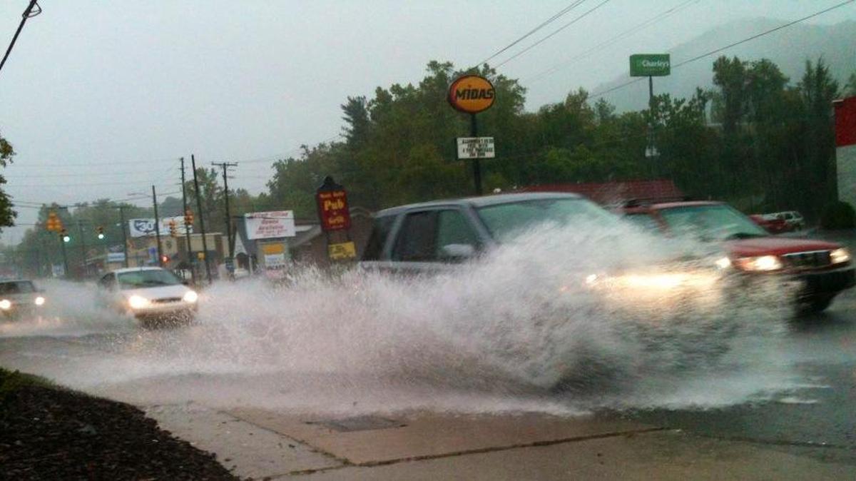 
Cars splash through flooded streets Saturday in Asheville.
