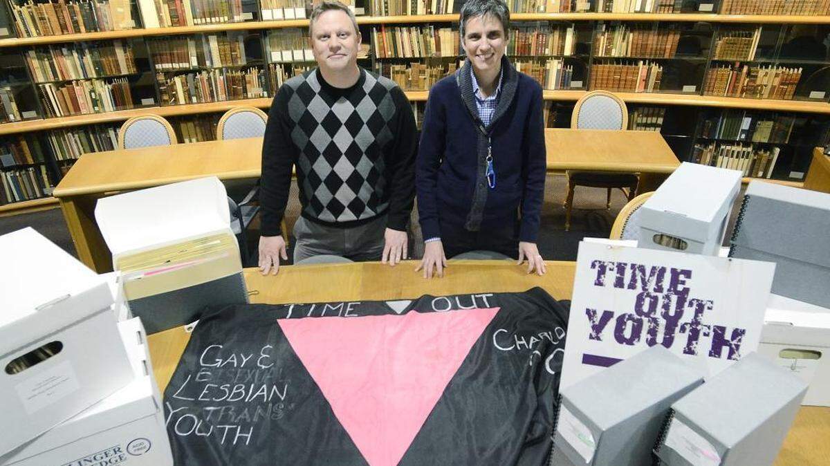 Josh Burford (left), asst. director Multicultural Resource Center, is launching an oral history project to talk to historical figures in the LGBT community for their perspectives on history. Burford and Dawn Schmitz, archivist at the Atkins Library, displayed some of the collection on Thursday, Feb. 11, 2016.