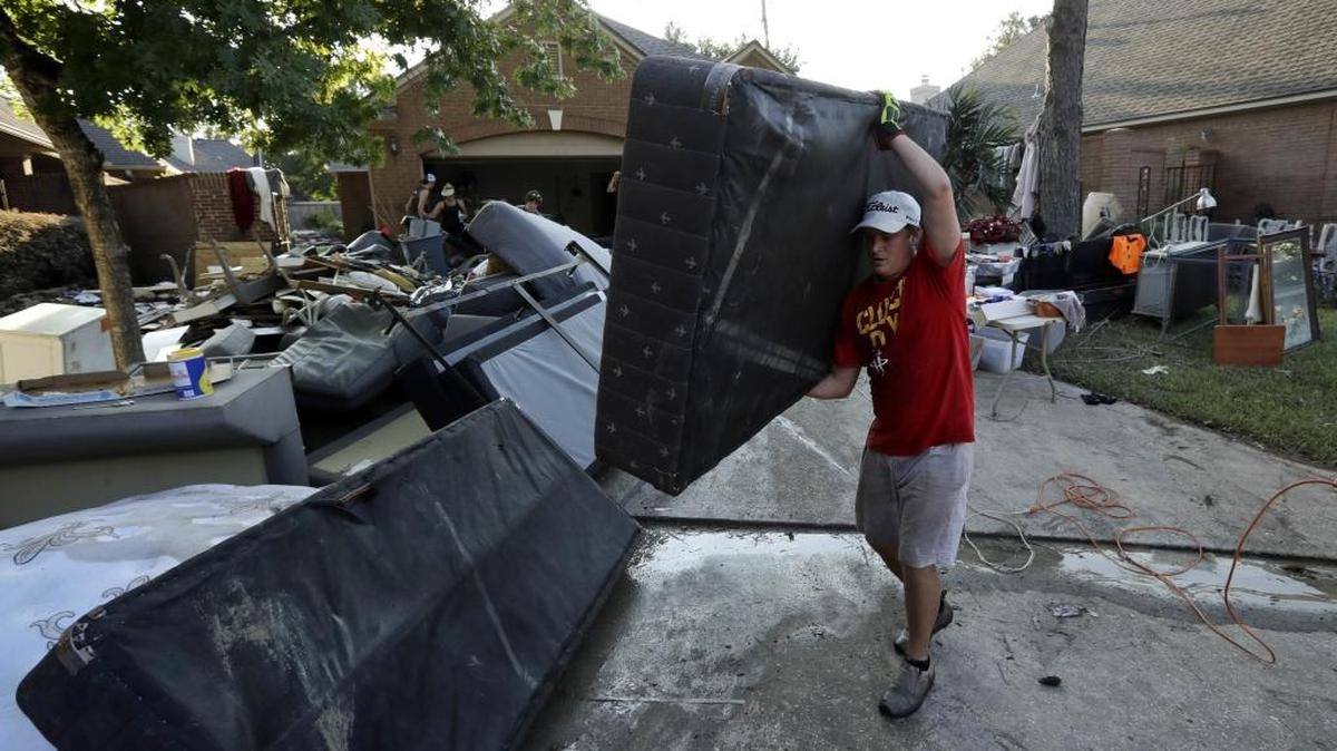 Tyler Moody removes a mattress from a friend's home after floodwaters from Tropical Storm Harvey drenched Houston on Thursday.