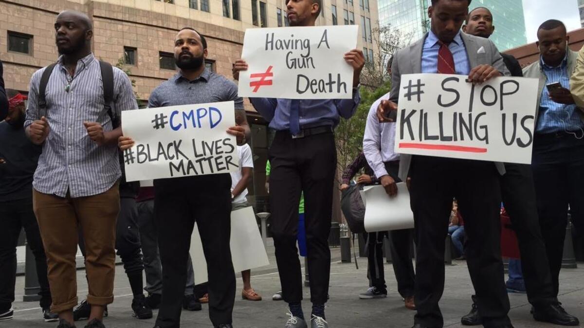 People gather at Trade and Tryon Streets in Charlotte to protest the CMPD officer-involved fatal shooting of a man in the University City area on Tuesday evening.
