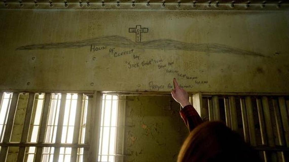 Meghan Cooke, a spokesperson for the Mecklenburg County District Attorney’s office, points out a piece of graffiti on a wall at the old Mecklenburg County jail. The jail, which sits atop the old courthouse on Trade street, has been empty and abandoned since 1969.