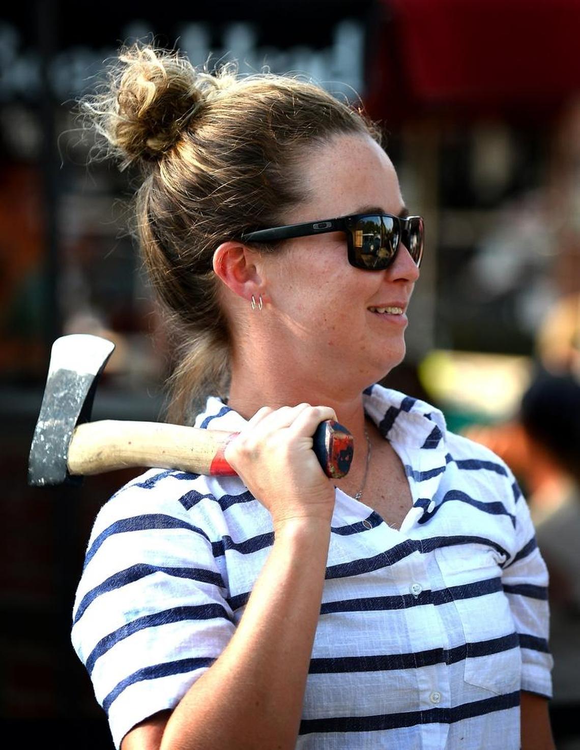 Alison Gulledge smiles as she waits to throw an axe at the Common Market in Plaza Midwood. Gulledge and others participated in a mobile axe throwing event hosted by Lumberjaxe.
