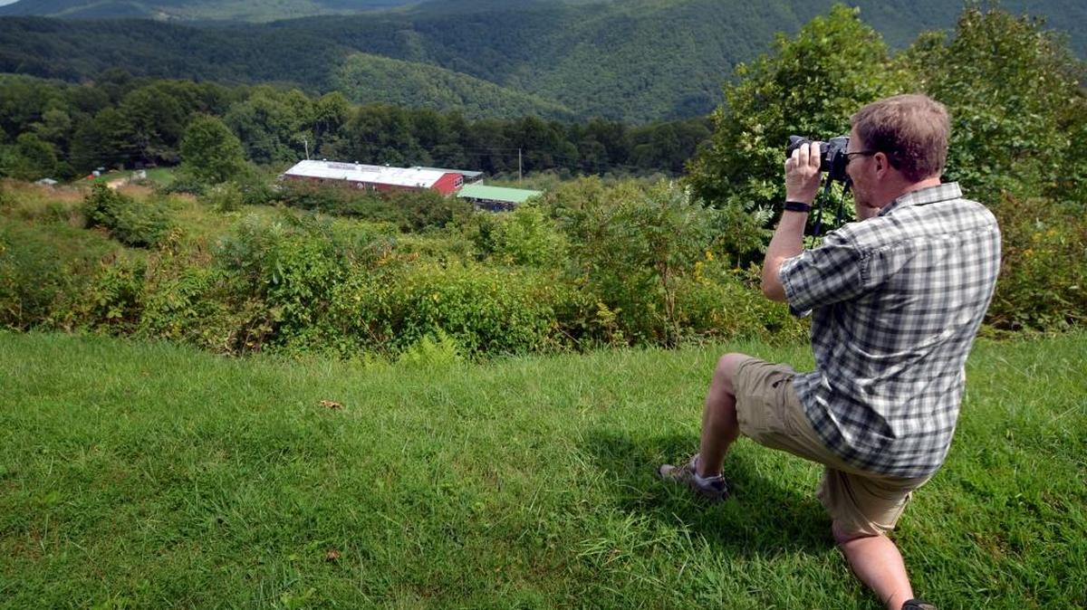 Joe Ayres of Raleigh, visiting the Blue Ridge Parkway in September, photographs the Orchard at Altapass. Nearly all the view is protected, including Jackson Knob at right.
