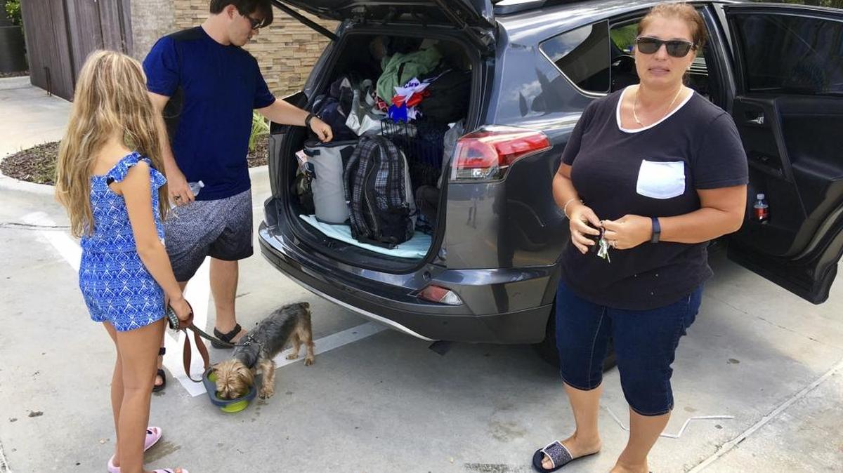 Hurricane Irma evacuee Mari Michaud, right, takes a break from the drive north with daughter Zoey Michaud and son Neal Michaud Jr., at a convenience store in Ormond Beach, Fla., on Thursday. Michaud and others fleeing Irma describe spending hours on the road amid a constant search for gasoline and lodging.