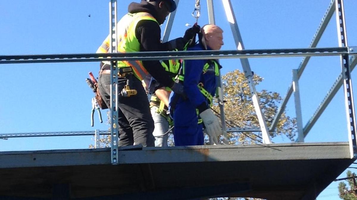 During a training exercise at WB Moore Company of Charlotte, workers use a mannequin to practice the steps for lifting an injured worker out of a manhole.