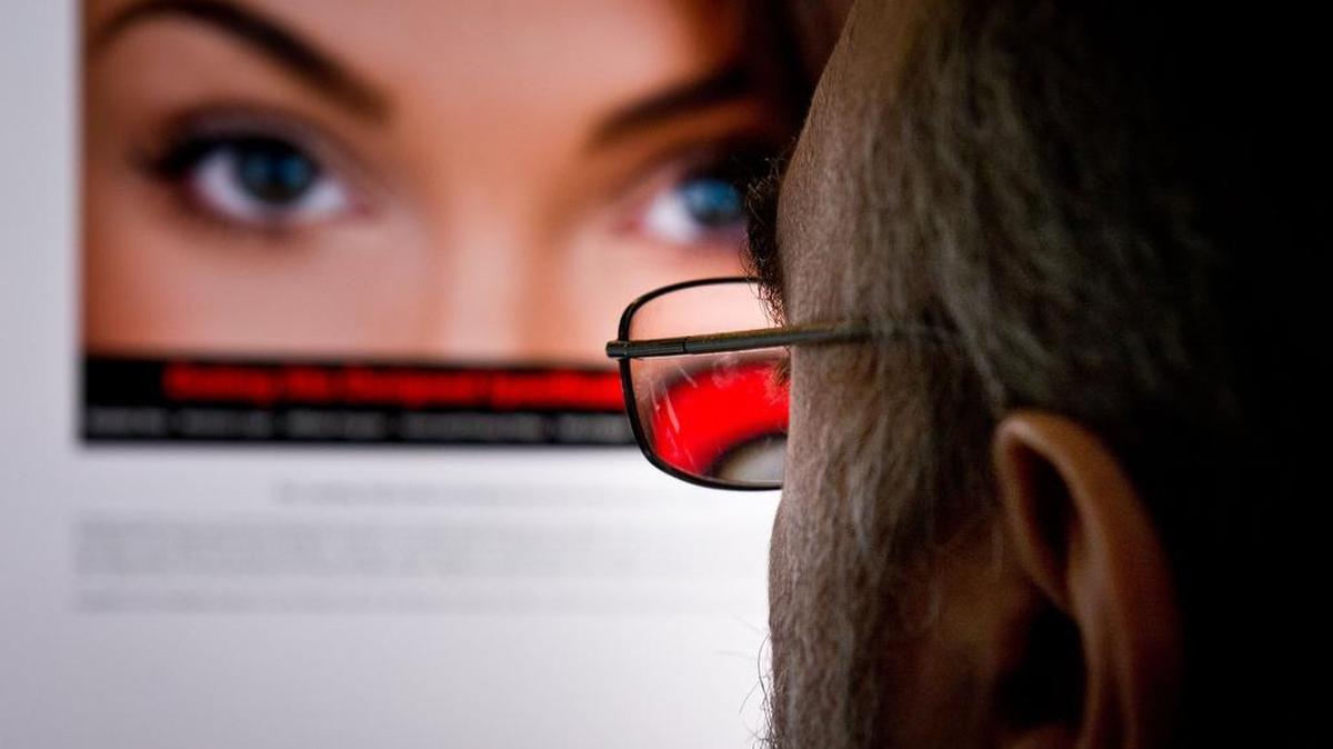 
(FILES) - A file picture taken on February 10, 2014 shows a man as he looks at a dating site on his computer in Washington,DC. The chief executive of dating for adulterers website Ashley Madison stepped down on August 28, 2015 after hackers leaked its membership list online. 
