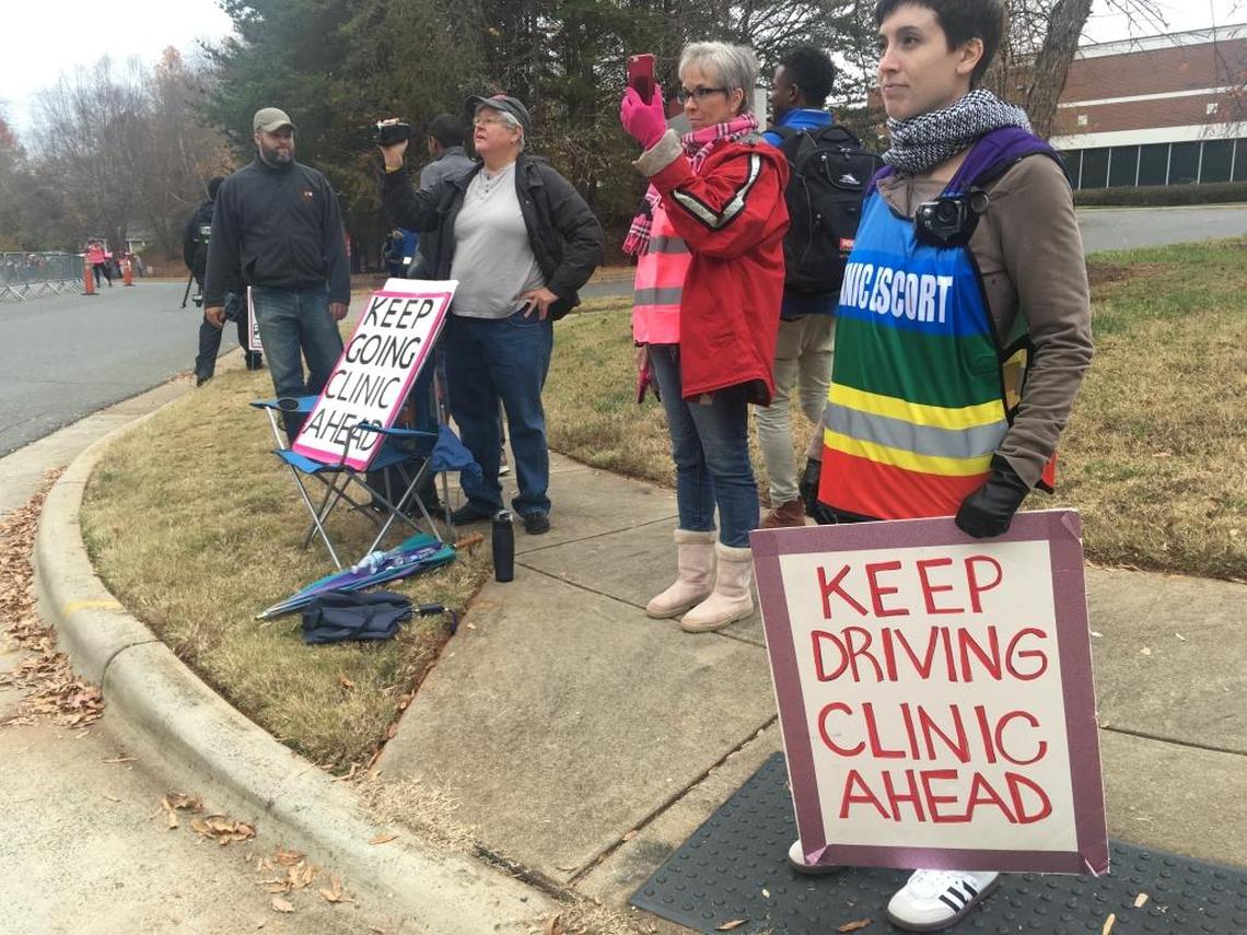 Volunteers at A Preferred Women’s Health try to direct women toward the clinic amid a large pro-life prayer walk.