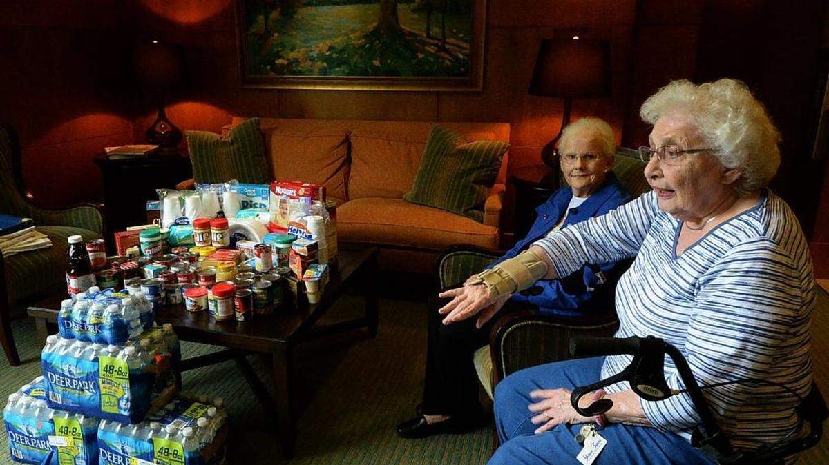 
Sharon Towers residents Mitzi Folk, front, and Frances Taylor, back, sit with a collection of items collected by seniors at Sharon Towers Assisted Living for flood relief efforts in Columbia. Folk and Taylor were two of the residents who contributed to the flood relief effort. 
