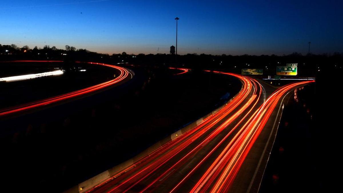 Motorists stream down a dark stretch of Charlotte’s Brookshire Freeway in this March photo. The city is expected to get about 3,300 new roadway lighting fixtures under a $30.8 million state contract that will improve lighting statewide.