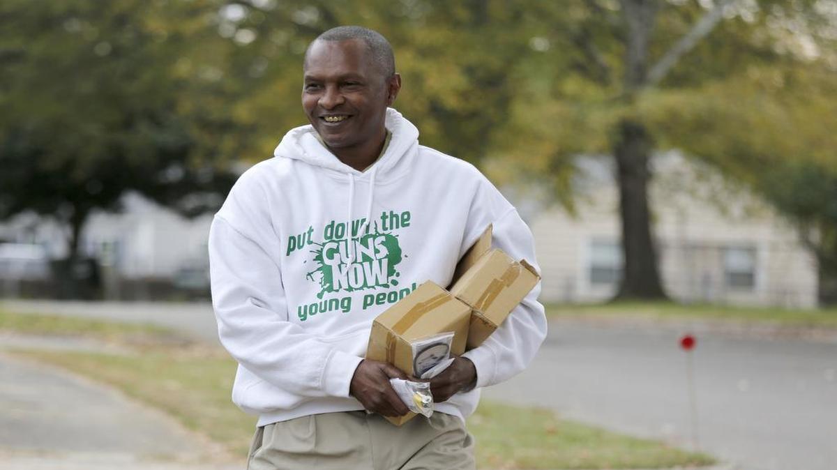 Jack Logan, owner and founder of Put Down the Guns Now Young People, goes door-to-door to hand out gun locks Tuesday on Oconee Ave. in the Rock Hill neighborhood where a 3-year-old boy accidentally shot and killed himself Sunday.