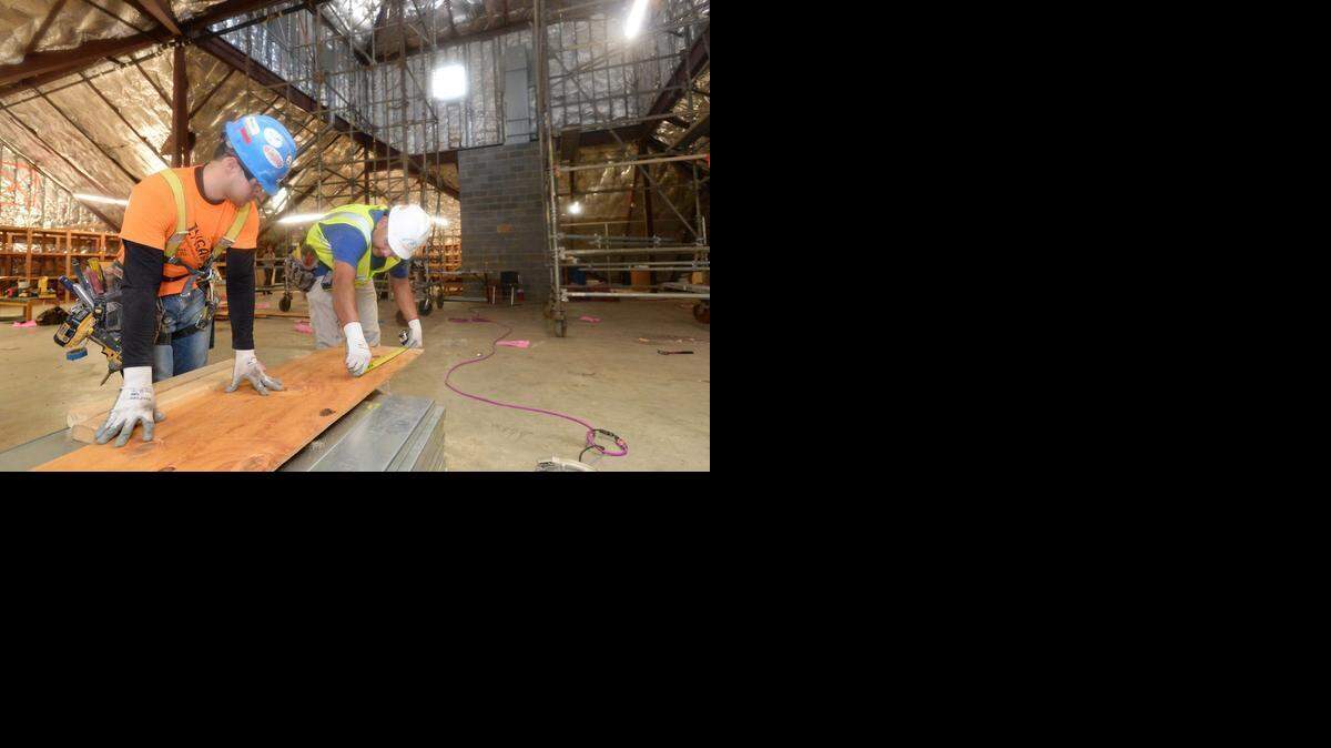 
Workers with Precision Walls of Charlotte Freddie Martinez, left, and Guillermo Fuentes measure lumber that will be cut to protect new window openings that have been installed as part of the third floor expansion on March 11, 2015, at the Salvation Army Center of Hope shelter. The project will add space for 64 shelter beds.
