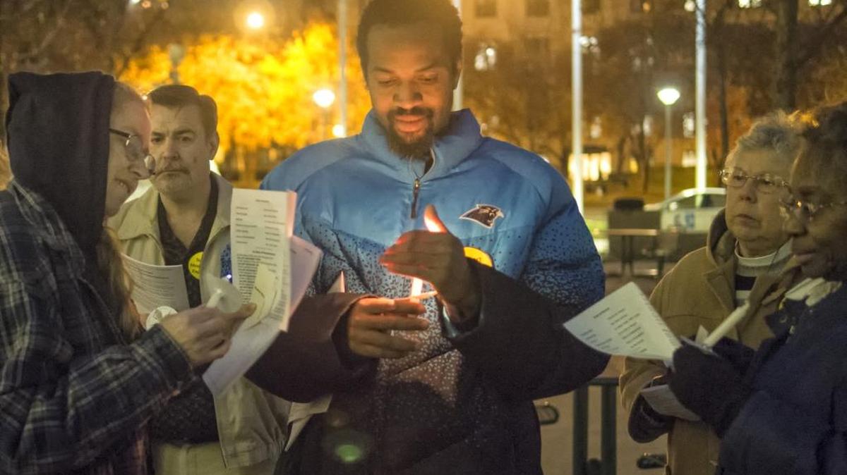 A scene from one of Charlotte’s past candlelight vigils honoring those who died while homeless. Solomon Agunbigcle, center in blue, was formerly homeless when he participated in this event.