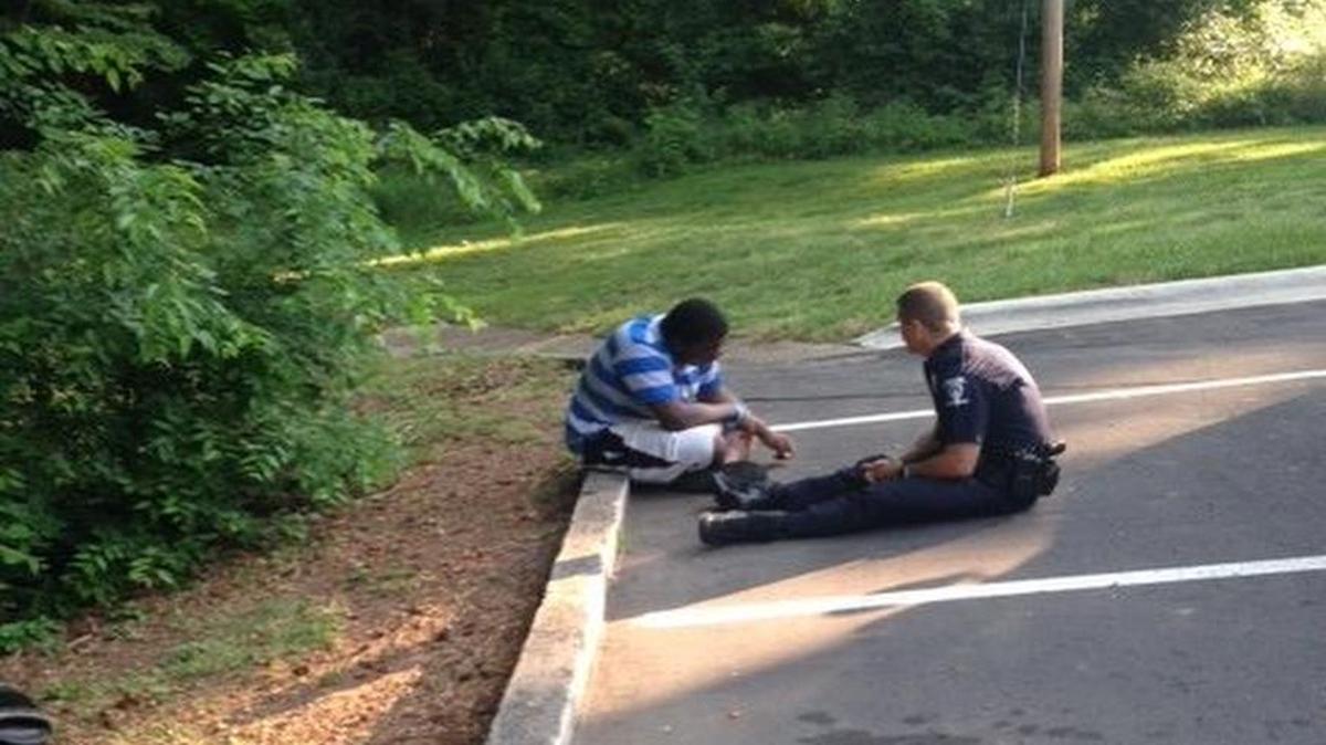 Charlotte-Mecklenburg police Officer Tim Purdy calms a potentially suicidal high school student by sitting next to him on the ground, talking things through and even getting him laughing.