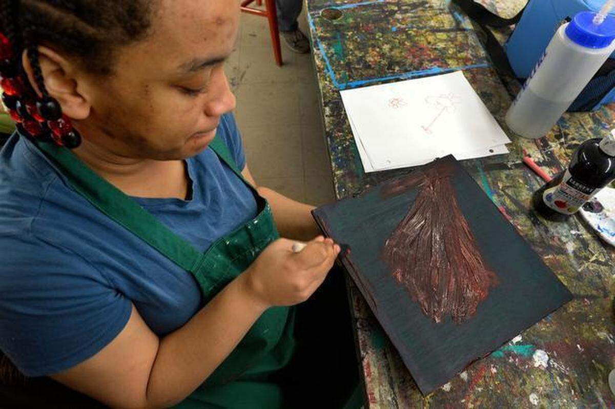 UMAR artist Lashad Gant paints a flower at the Charlotte UMAR Arts Center in 2015.