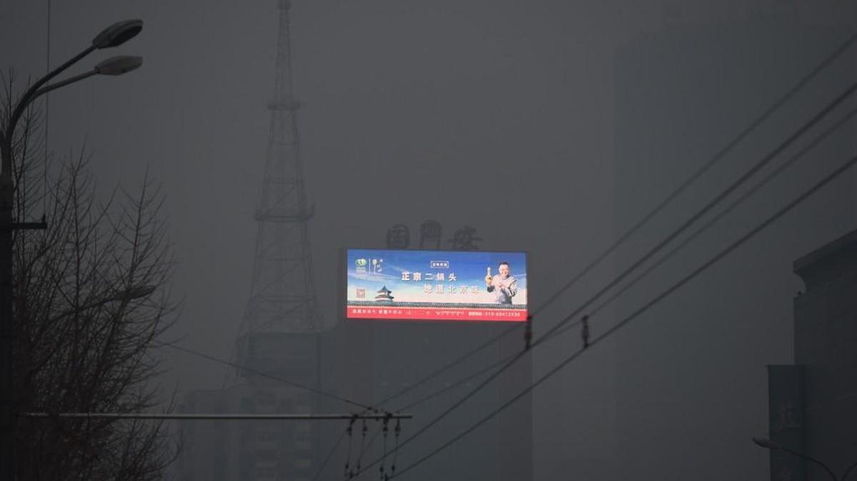 A scene of blue skies over the Temple of Heaven is seen on an electronic billboard through pollution in Beijing on November 27, 2015. China is the world's largest polluter and will be a key player at next week's climate change talks in Paris in the face of disputes over whether developed or developing countries should bear more of the burden for reducing emissions.